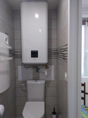 La salle de bains est pourvue de toilettes blanches avec une horloge au-dessus. dans l'établissement Gîte Rosie, à Saint-Blimont