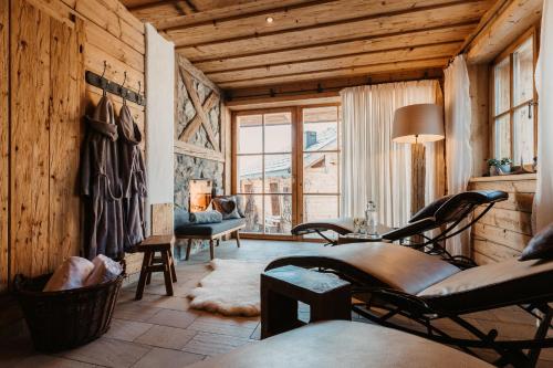 a living room with wooden walls and a room with chairs at Chaletdorf BERGHERZ in Sankt Johann im Pongau