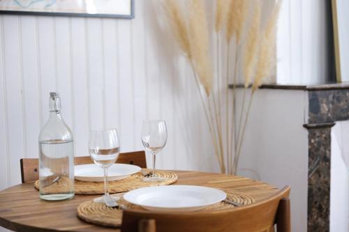 a table with two glasses and a bottle of wine at Le Studio de la Bastide - Classé 2 étoiles - Libourne in Libourne