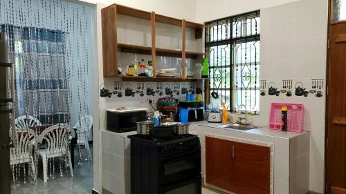 a kitchen with a sink and a stove in a room at Gabibo Kendwa Beach House in Kendwa