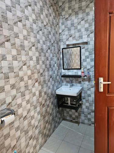 a bathroom with a sink and a mirror at B-MORE COMFORT STAY in Boma la Ngombe
