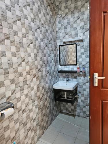 un baño con lavabo y espejo en B-MORE COMFORT STAY, en Boma la Ngombe