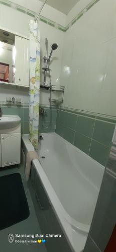 a bathroom with a bath tub and a sink at Apartment in historical centre in Odesa