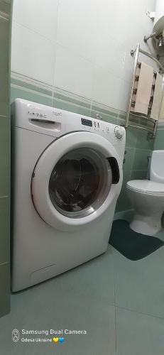 a washing machine in a bathroom with a toilet at Apartment in historical centre in Odesa
