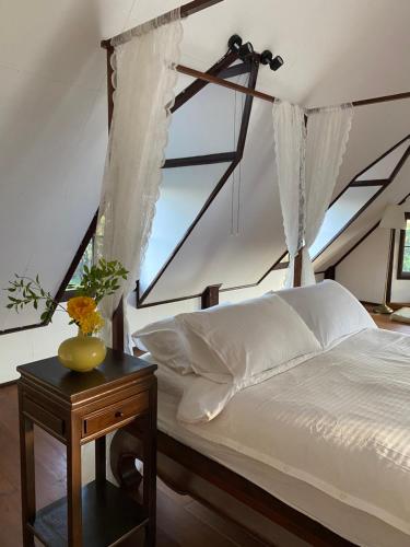 - une chambre avec un lit avec des rideaux et une table dans l'établissement Cozycomo Chiang Dao - Pha Mok, à Amphoe Chiang Dao
