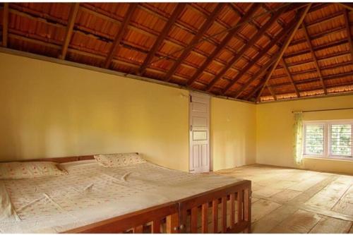 1 dormitorio con 1 cama grande y techo de madera en Daisy Land - Farm Stay. (Group of 4+ guests), en Cherambane