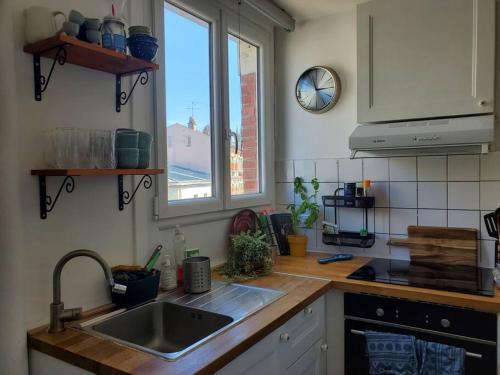 une cuisine avec un évier et une fenêtre dans l'établissement Nid cosy au coeur de Saint-Denis, à Saint-Denis