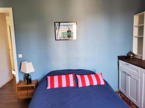 - une chambre bleue avec un lit et 2 oreillers rouges dans l'établissement Nid cosy au coeur de Saint-Denis, à Saint-Denis