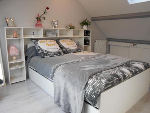 een slaapkamer met een groot bed met grijze lakens en kussens bij Paris Magic - Villepinte Exhibition Center in Sevran
