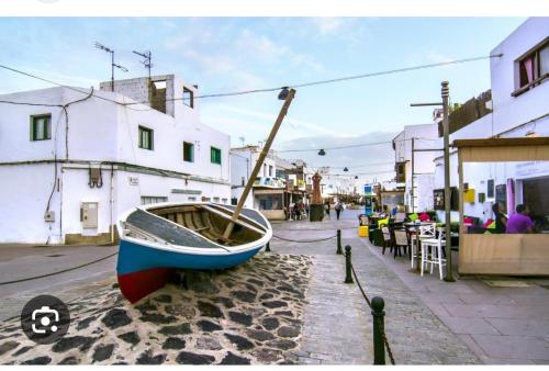 un pequeño barco sentado al lado de una calle en Casa Matilde, en Corralejo