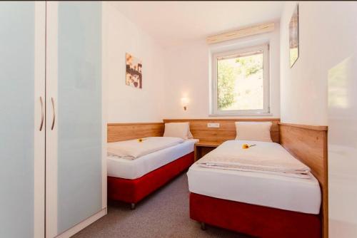 2 łóżka w małym pokoju z oknem w obiekcie Gletscherblick Resort Kaprun by Jara w Kaprunie