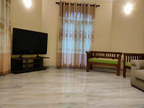 a living room with a flat screen tv and a couch at Heaven Palace in Kandy