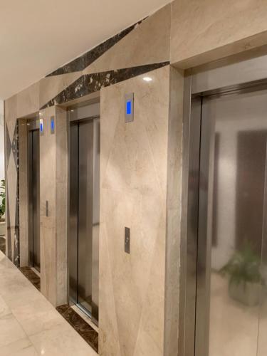 une rangée de portes d'ascenseur dans un bâtiment dans l'établissement charmant appartement a oran gambetta pour famille, à Oran