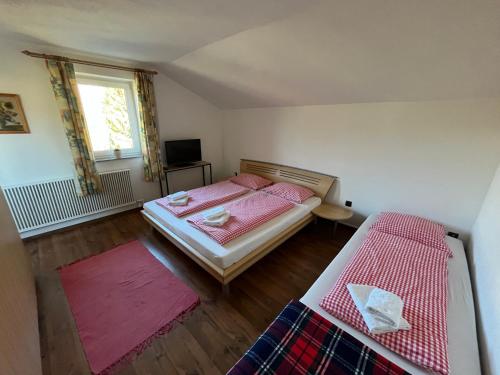 - une petite chambre avec 2 lits et une télévision dans l'établissement Ferienwohnung am Stambach, à Bad Goisern