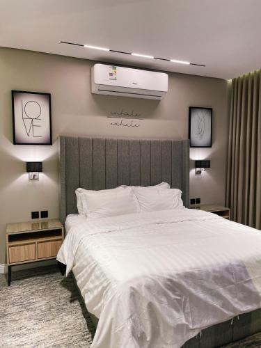 1 dormitorio con 1 cama blanca grande y aire acondicionado en أجنحة لافينا الخاصة, en Yanbu