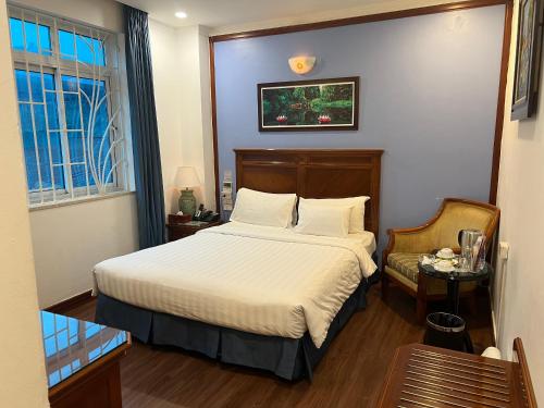 a bedroom with a bed and a chair and a window at A25 Hotel - 19 Phan Đình Phùng in Hanoi