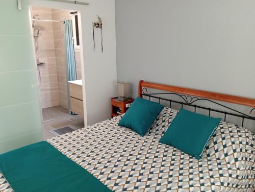 a bedroom with a bed with two blue pillows at Almendra34480 in Magalas