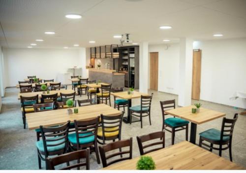 a restaurant with wooden tables and chairs at Hotel Central Vis a Vis in Mainz
