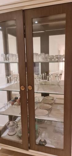 a glass cabinet with plates and dishes in it at Breeze 2 in Dubai
