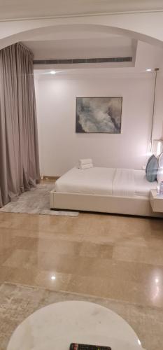 een slaapkamer met een bed en een schilderij aan de muur bij Breeze 2 in Dubai