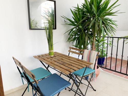 a wooden table and chairs with plants on a balcony at Stunning Duplex in Capistrano Playa, Nerja in Nerja