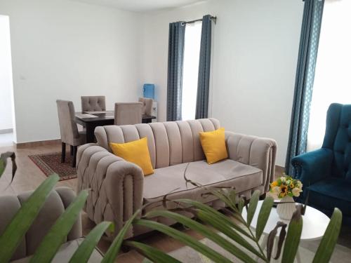 a living room with a couch with yellow pillows at Sana's crib in Kitengela 