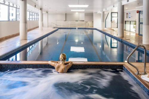 a woman is sitting in a swimming pool at Super comfortable quiet room in Sydney