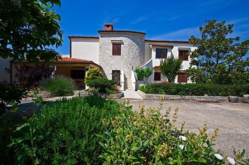 een groot wit huis met een rood dak bij Apartmani Tara Medulin in Medulin