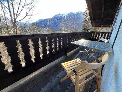 a table and a chair on a balcony with a view at Ferienwohnung am Stambach in Bad Goisern