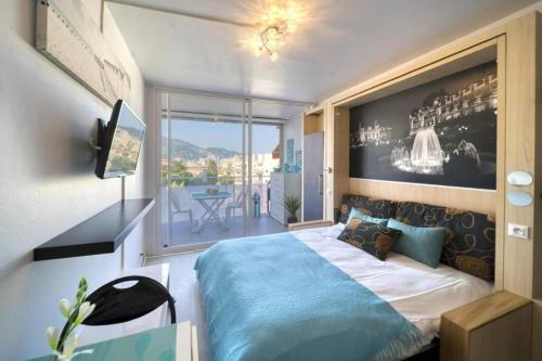 une chambre avec un grand lit et un balcon dans l'établissement Studio Monaco, à Roquebrune-Cap-Martin