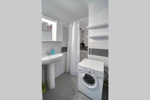 a bathroom with a washing machine and a sink at Studio Monaco in Roquebrune-Cap-Martin
