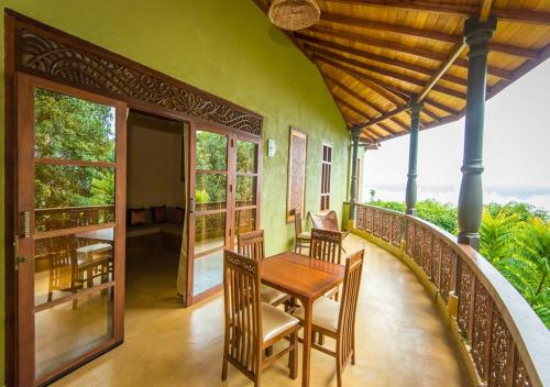 een balkon van een huis met een tafel en stoelen bij Galavilla Boutique Hotel & Spa in Kandy