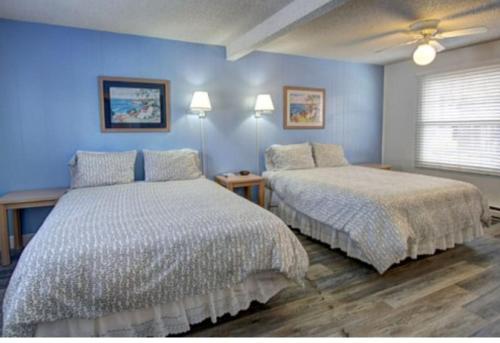 two beds in a bedroom with blue walls at Pinecone Park in Wimauma