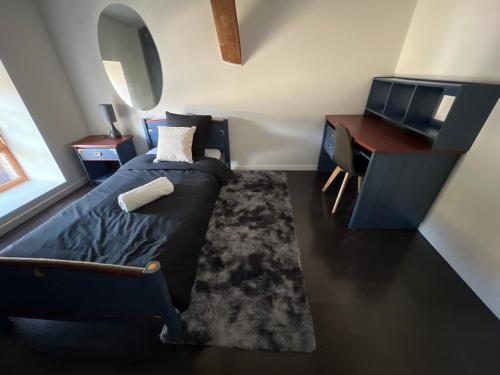 1 dormitorio con cama, escritorio y espejo en La mansarde de la Lône, en La Roche-de-Glun