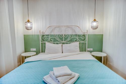 a bedroom with a blue bed with two towels on it at Zen Oasis Tineretului Park in Bucharest