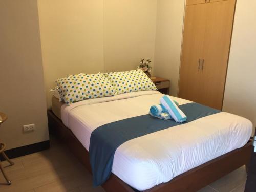 a bedroom with a bed with a blue object on it at Mactan Cebu Beach Condo in Punta Engaño