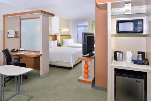 a hotel room with a bed and a tv at SpringHill Suites Kingman Route 66 in Kingman
