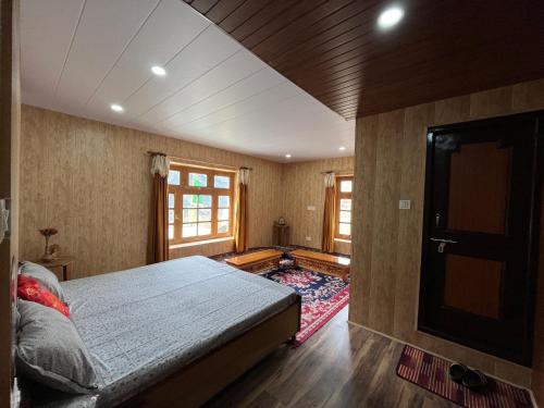 a bedroom with a large bed and a rug at SNOWFLAKE Homestay in Gondla
