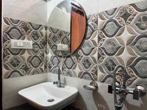 een badkamer met een wastafel en een spiegel bij SNOWFLAKE Homestay in Gondla