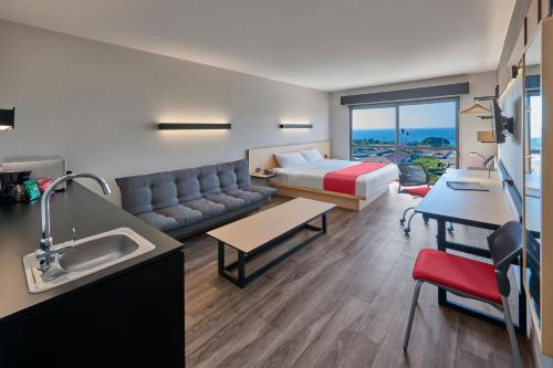 a living room with a couch and a bed in a room at City Express Plus by Marriott Puerto Vallarta in Puerto Vallarta