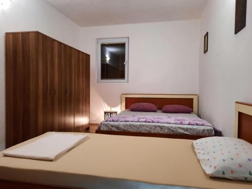 1 dormitorio con 2 camas y ventana en Apartmani na moru en Bar