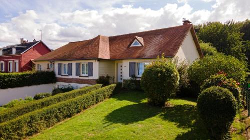 ein weißes Haus mit einem braunen Dach und einem Hof in der Unterkunft Chambres d'Ault in Ault