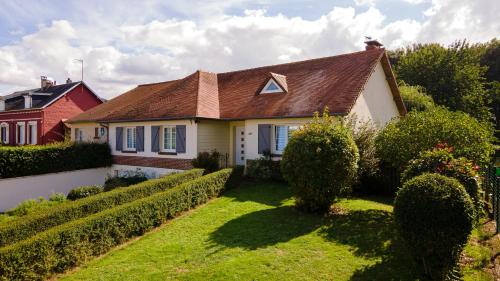 a white house with a brown roof and a yard at Chambres d'Ault in Ault