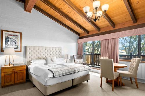 布勒山的住宿－格里莫斯酒店，卧室配有一张床和一张桌子及椅子