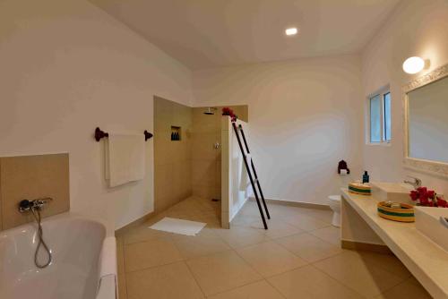 ein Badezimmer mit einer Badewanne, einem Waschbecken, einem WC und einer Badewanne in der Unterkunft Mnarani Beach Club in Kilifi