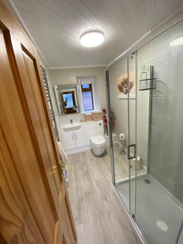 a bathroom with a glass shower and a toilet at Lyngarrie in Dufftown