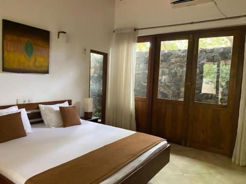 a bedroom with a large bed and a window at Twin Blocks Nature Resort in Anuradhapura
