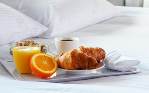 ein Frühstückstablett mit Croissants und Orangen auf dem Bett in der Unterkunft The Briarcroft in Goole