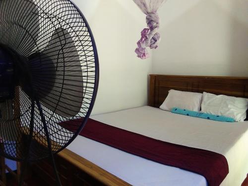 a room with a bed with a large fan at River Side Cottage in Udawalawe