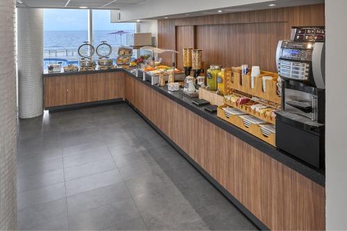 a food counter in a restaurant with the ocean in the background at City Express by Marriott Veracruz in Veracruz